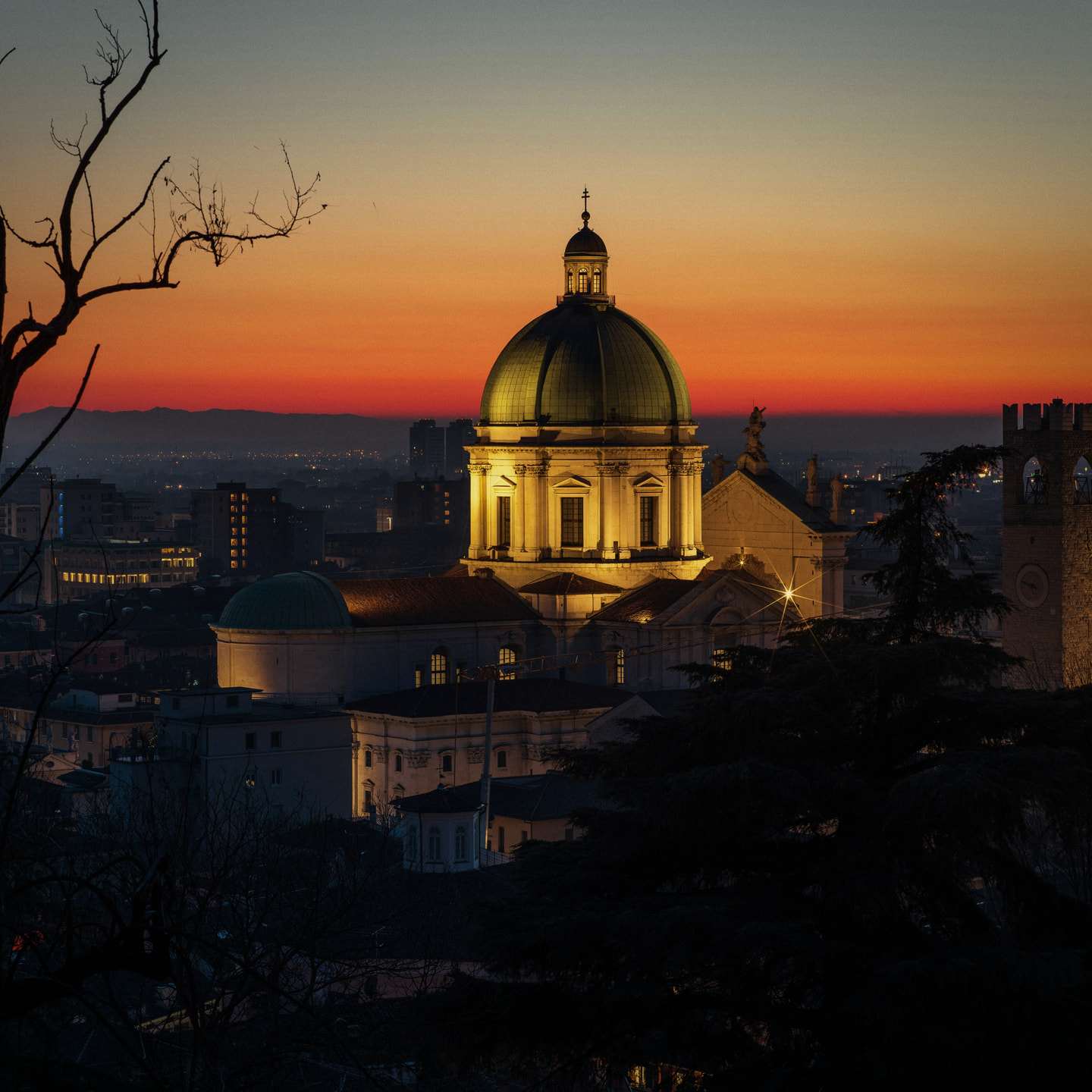 Brescia, il Duomo Nuovo illuminato al tramonto sopra i tetti della città